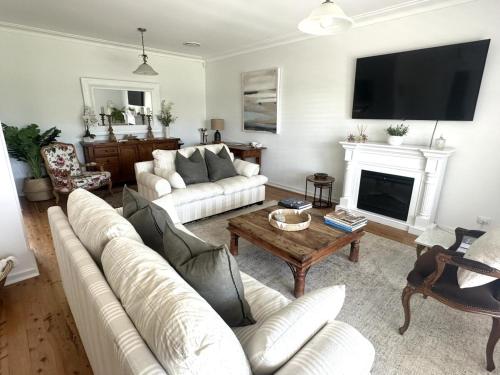 a living room with a white couch and a fireplace at Luxberry House - In the heart of Berry in Berry