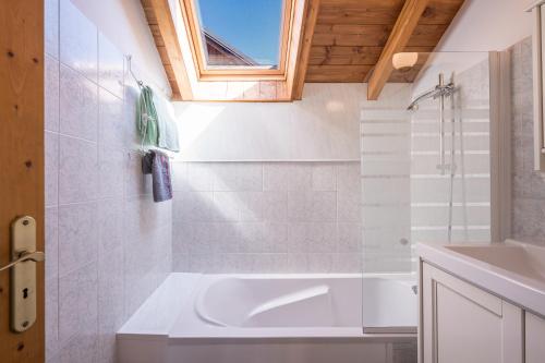 Un baño blanco con bañera y lavabo. en La Mouliniere 1, en Valloire