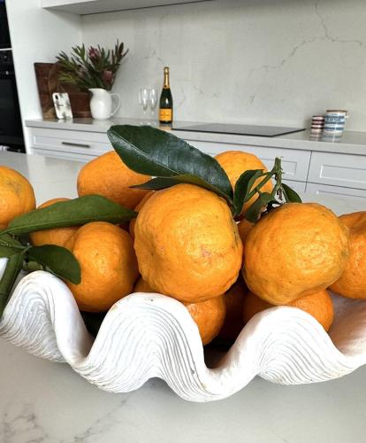 a pile of oranges in a bowl on a counter at Luxberry House - In the heart of Berry in Berry