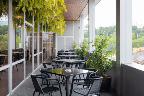 a row of tables and chairs on a balcony with plants at Hotel Navarras in Amarante