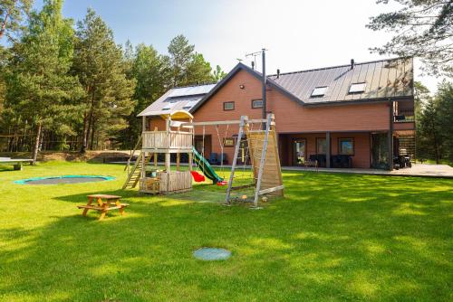 una casa con un parco giochi nel cortile di SPILAS a Pape