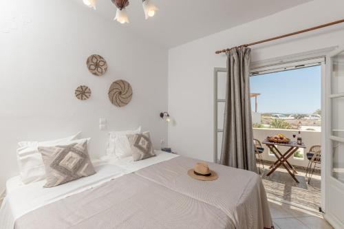 a white bedroom with a bed and a balcony at Marine Dream in Plaka