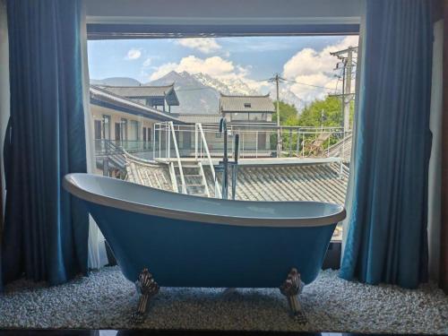 a blue bath tub sitting in front of a window at 玉龙白沙普宿客栈 in Lijiang