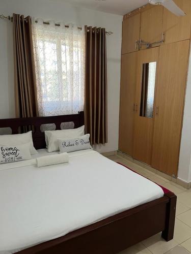 ein Schlafzimmer mit einem großen Bett mit weißer Bettwäsche in der Unterkunft Joy BNB in Mombasa