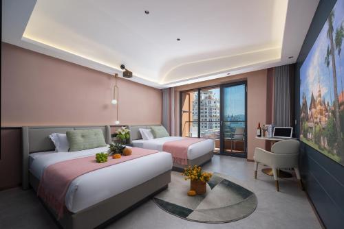 a hotel room with two beds and a tv at Naga Hotel in Jinghong