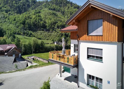 a house with a balcony with a mountain in the background at Landhaus Seppenbauer in Bad Ischl