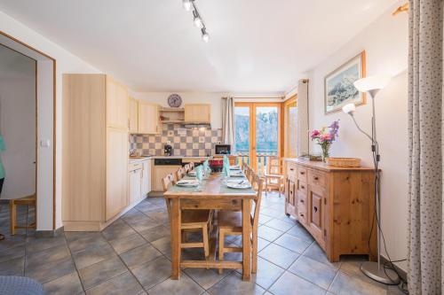 une cuisine et une salle à manger avec une table et des chaises dans l'établissement La mouliniere 2, à Valloire