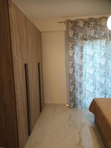 a bedroom with a large window and marble floor at Twins house pool 2 in Nikiti
