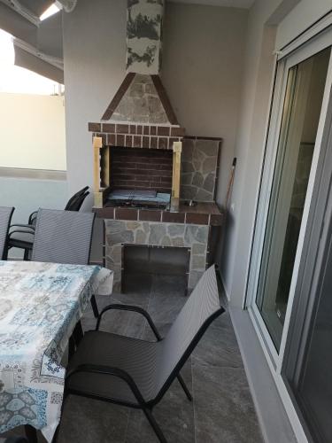 a living room with a fireplace and a table and chairs at Twins house pool 2 in Nikiti
