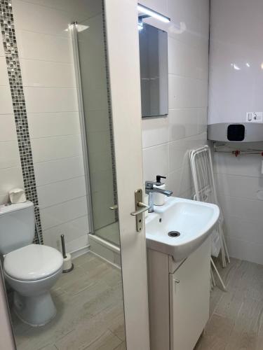 une salle de bain blanche avec des toilettes et un lavabo dans l'établissement Studio Deauville PiscineTennisParking, à Deauville
