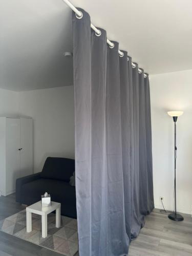 - un salon avec un canapé et des rideaux dans l'établissement Studio Deauville PiscineTennisParking, à Deauville