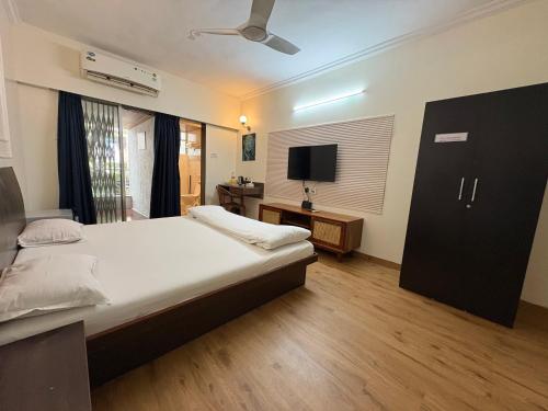 a bedroom with a large bed and a television at Apple Tree Apartments Koregaon Park in Pune