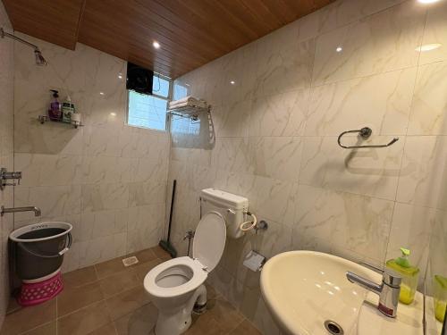 a bathroom with a toilet and a sink at Apple Tree Apartments Koregaon Park in Pune