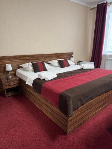 a bedroom with a large bed with a red carpet at Premier Inn Astana in Astana
