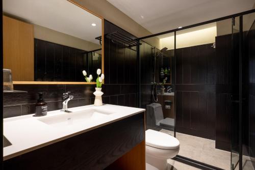 a bathroom with a white sink and a toilet at Beijing Tangfu Nanluoguxiang Tian an Men Lama Temple San Li Tun Snack Street Hotel,Free Laundry Dry Service and Free Afternoon Tea &professional Free Tour Ticket Service with English Speaking Staff in Beijing