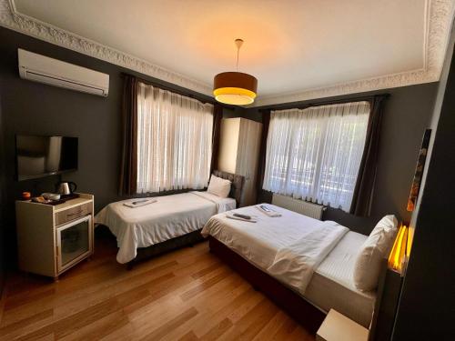 イスタンブールにあるArmoni City Otel Kadıköyのベッド2台とテレビがあるホテルの部屋