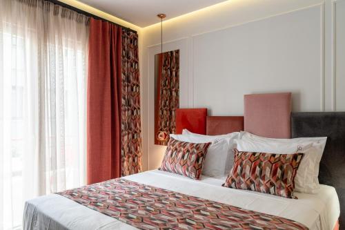 a bedroom with a large bed with red curtains at Garment District Suites in Athens