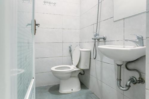 a bathroom with a toilet and a sink at RedDoorz at Seindo Hotel Medan in Sunggal