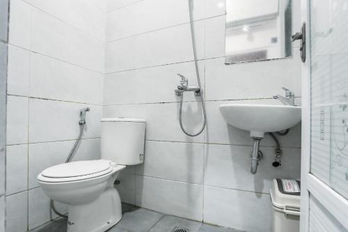 a bathroom with a toilet and a sink at RedDoorz at Seindo Hotel Medan in Sunggal