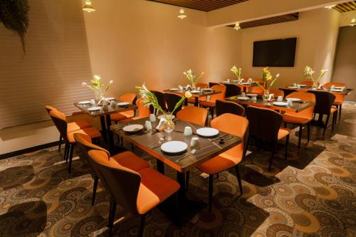 Un comedor con mesas y sillas y una mampara. en Hotel Ritvis Elite, en Bangalore