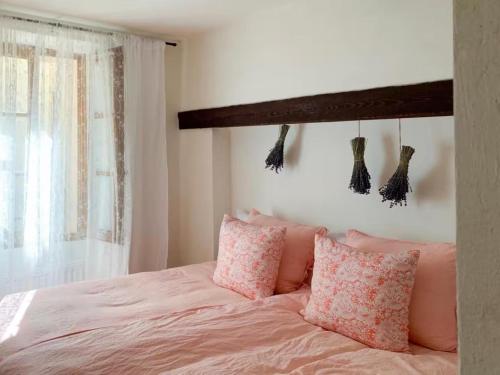 a bedroom with a bed with pink pillows and a window at Le Karlstrom - Charmante maison au coeur du Viel Antibes in Antibes