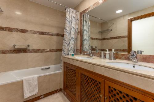 ein Badezimmer mit Waschbecken, Badewanne und Spiegel in der Unterkunft MTR - Marbella Temporary Rent Two Bedrooms Apartment Av del Mar in Marbella