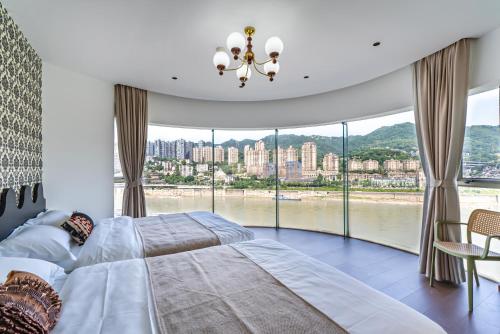 a bedroom with two beds and a large window at Aixin Mountain City Zhijiang Homestay in Chongqing