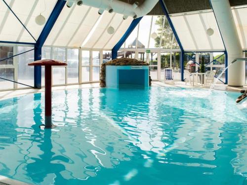 a swimming pool with blue water in a building at Modern Apartment With Pool & Fitness in Hejls