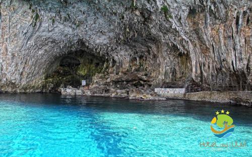 a boat in the water in front of a cave at Hotel Degli Ulivi in Castro di Lecce