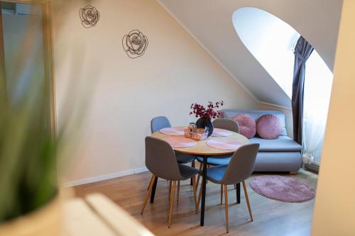 a dining room with a table and chairs and a couch at Lucsony Apartman in Mosonmagyaróvár