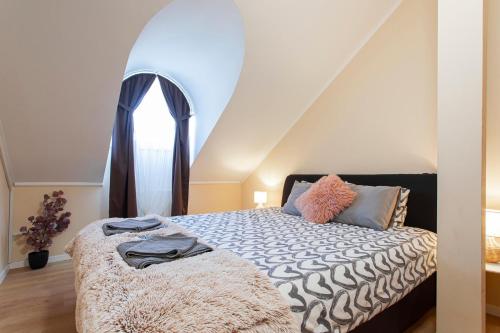 a bedroom with a bed with an attic at Lucsony Apartman in Mosonmagyaróvár