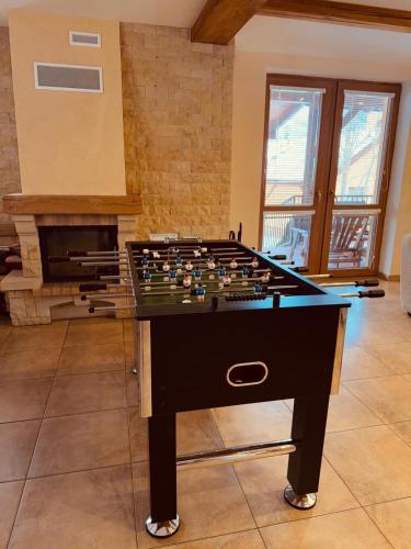 a foosball table in a room with a fireplace at Ubytování Heřmanka in Špičák