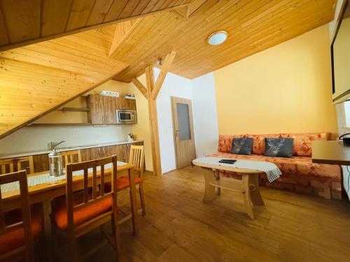 a living room with a table and a couch at Ubytování Heřmanka in Špičák