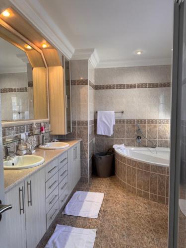 un bagno con due lavandini e una vasca da bagno di Waterfront D8 Unit a Swakopmund