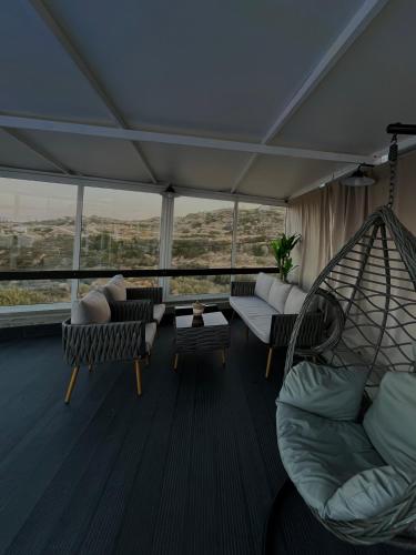a living room with couches and a hammock at Serenity Villa in Karpathos Town
