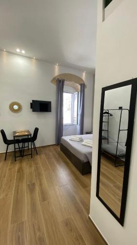 um quarto com uma cama, um espelho e uma mesa em Arco Vanese em Bari