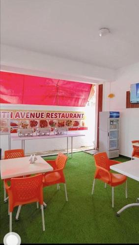 ein Zimmer mit roten Stühlen und Tischen und einer Küche in der Unterkunft Joy BNB in Mombasa