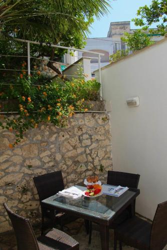 a table with chairs and a bowl of fruit on it at Hotel Degli Ulivi in Castro di Lecce