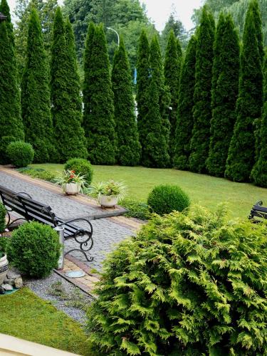 a park with a bench and a row of trees at Курортний Готель Золота Корона in Truskavets