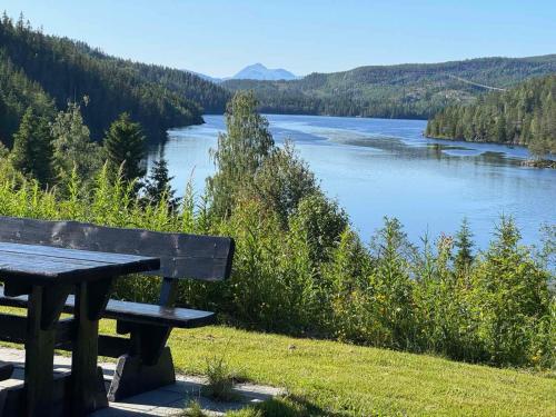 a picnic table sitting on a hill overlooking a river at Nystul Panorama in Lona