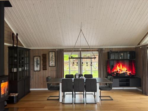 a dining room with a fireplace and a table and chairs at Nystul Panorama in Lona