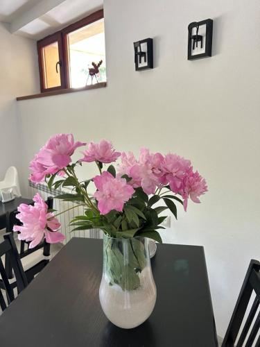 a vase of pink flowers sitting on a table at Villa Kmeller in Lviv