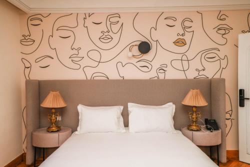 a bedroom with a bed with a wall with drawings on it at La Résidence in Rabat