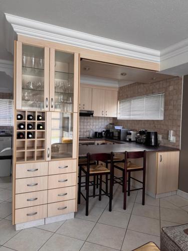 una cucina con mobili in legno, tavolo e sedie di Waterfront D8 Unit a Swakopmund