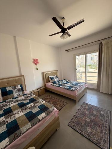 a bedroom with two beds and a ceiling fan at Chalet ground floor 3BR amwaj sidi abdelrahman in El Alamein