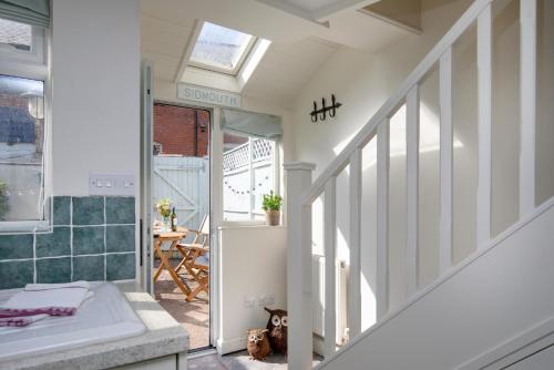 ein Badezimmer mit Badewanne und Treppe in einem Haus in der Unterkunft Anchor Cottage in Sidmouth