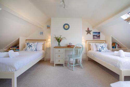 Schlafzimmer im Dachgeschoss mit 2 Betten und einem Schreibtisch in der Unterkunft Anchor Cottage in Sidmouth