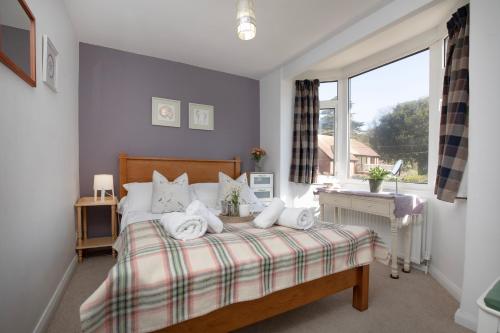 un dormitorio con una cama y una ventana en Waterside, en Sidmouth