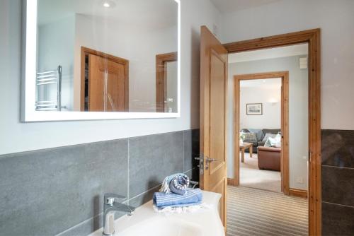 een badkamer met een wastafel en een spiegel aan de muur bij Balamory in Exmouth