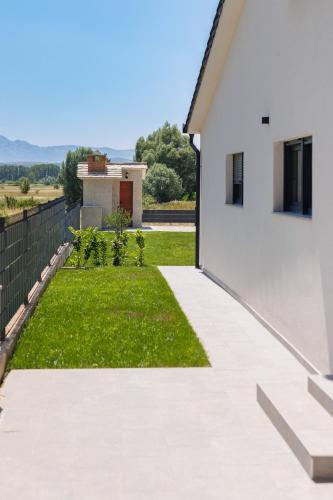a backyard with a lawn and a white house at Kuća Grab in Grab